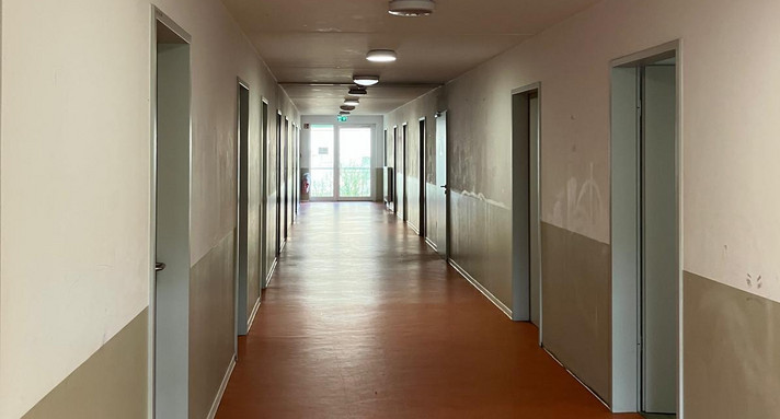 Das Bild zeigt einen Flur in einer Flüchtlingsunterkunft. 