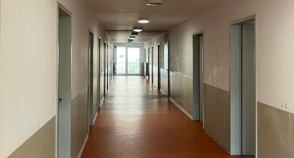 Das Bild zeigt einen Flur in einer Flüchtlingsunterkunft. 