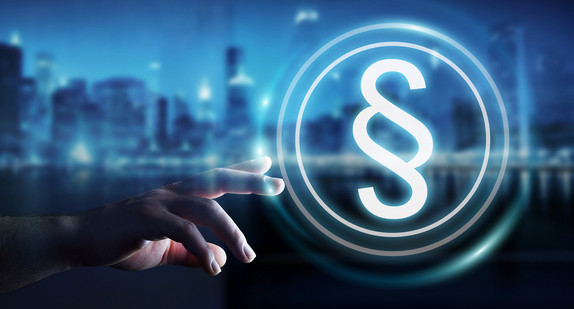 Eine Hand greift nach einem digitalen Paragrafen