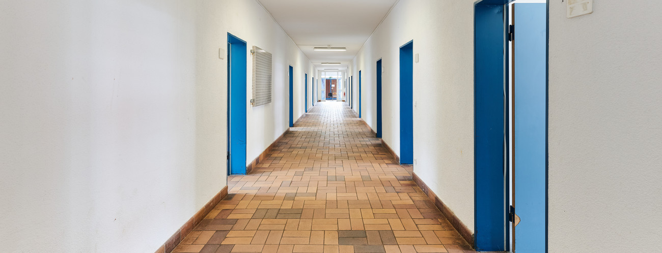 Das Bild zeigt einen Flur, von dem Zimmer abgehen.