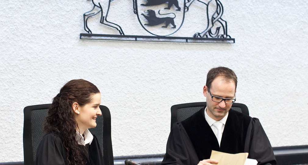 Das Bild zeigt eine Richterin und einen Richter