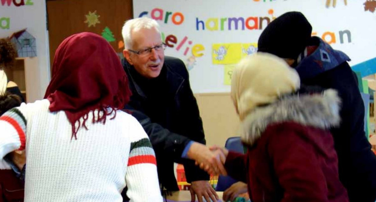 Das Bild zeigt die Ombudsperson Klaus Danner im Gespräch mit Geflüchteten