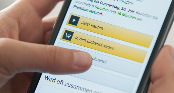 Eine Frau bedient die Smartphone-App eines Onlinehändlers. (Foto: © dpa)